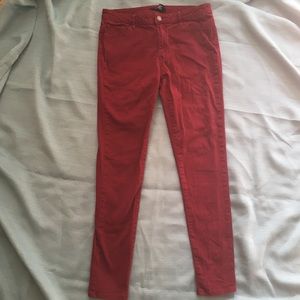 Burgundy skinny jeans.